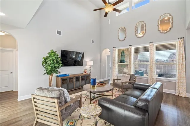 a living room with furniture a large window and a flat screen tv