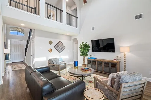 a living room with furniture a flat screen tv and kitchen view