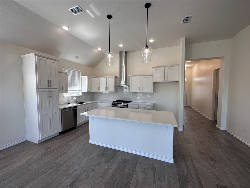 6506 Sam Houston Street Corpus Christi, TX 78414 - Photo 4 of 26 a large kitchen with white cabinets stainless steel appliances and wooden floor