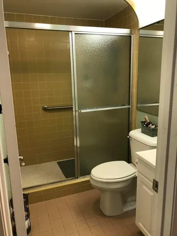 a bathroom with a toilet and a shower