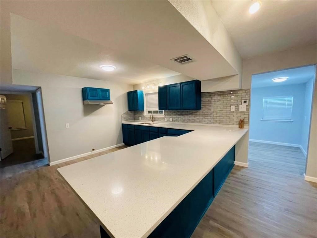 4309 Timon Boulevard Corpus Christi, TX 78402 - Photo 6 of 14 a large kitchen with stainless steel appliances a large counter top and wooden floor