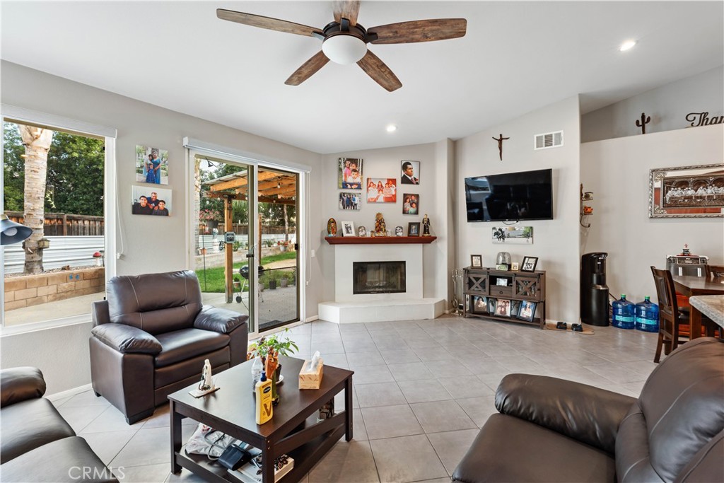 236 Jam Street Hemet, CA 92544 - Photo 10 of 36 a living room with furniture a fireplace and a flat screen tv