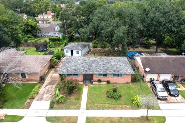 an aerial view of a house with a garden and large trees