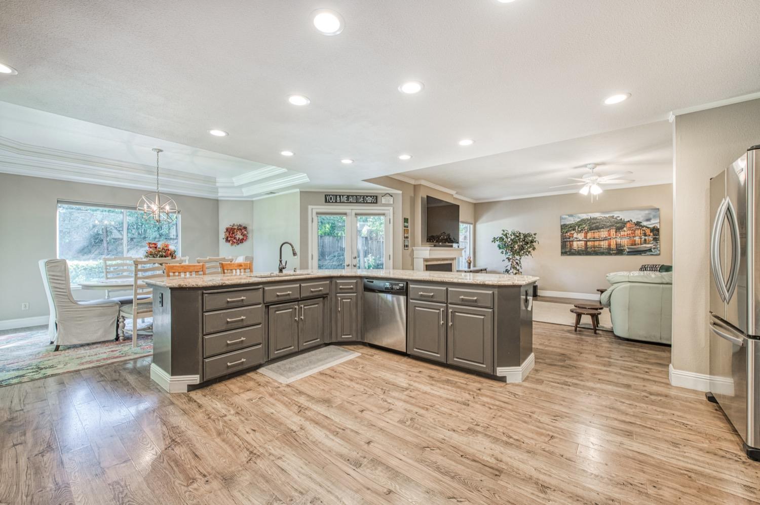 205 West Ridgepoint Drive Fresno, CA 93711 - Photo 23 of 49 a kitchen with stainless steel appliances kitchen island granite countertop a stove a sink a refrigerator and blue cabinets with wooden floor