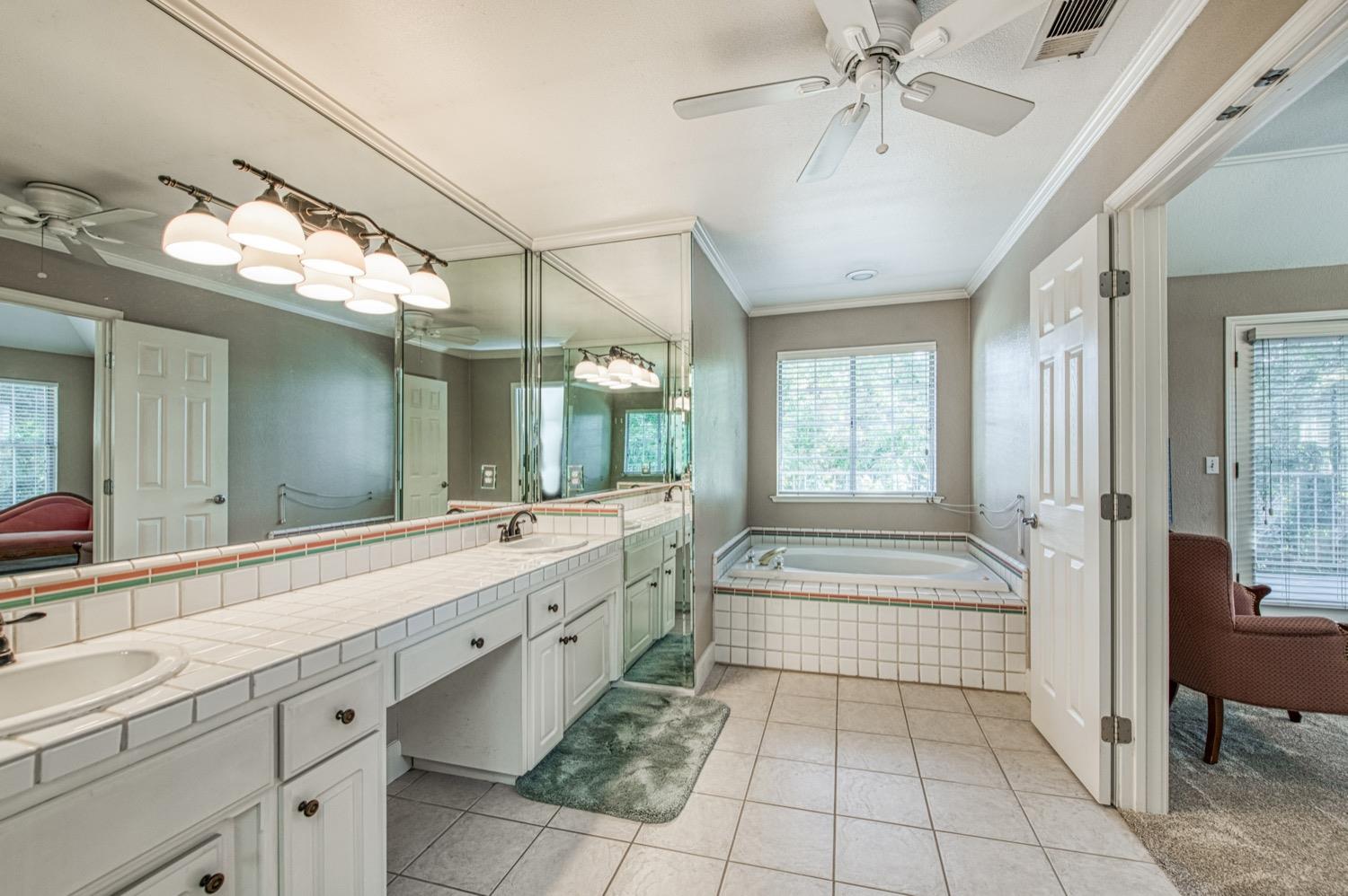 205 West Ridgepoint Drive Fresno, CA 93711 - Photo 37 of 49 a spacious bathroom with a double vanity sink a large mirror and a bathtub