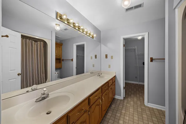 a spacious bathroom with a double vanity sink and a mirror