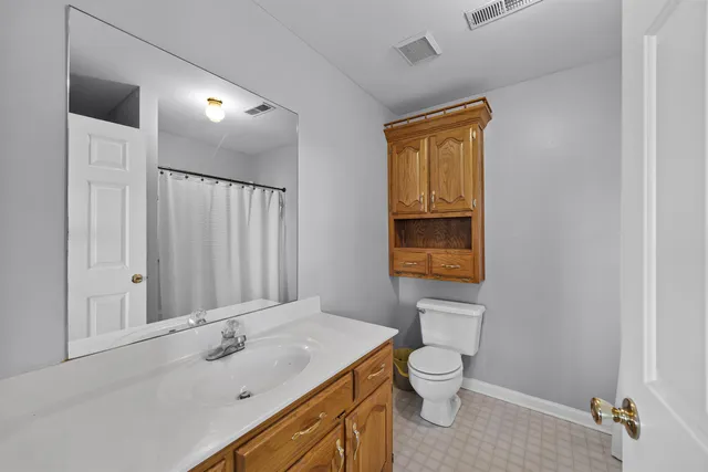a bathroom with a granite countertop toilet a sink and a mirror