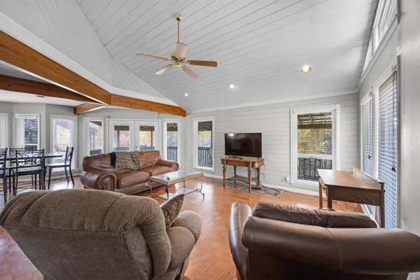 a living room with furniture a ceiling fan and a flat screen tv