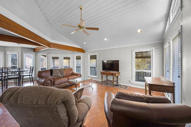 a living room with furniture a ceiling fan and a flat screen tv