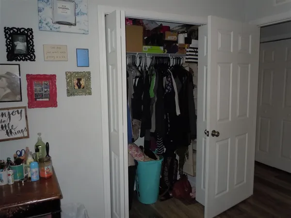 a view of walk in closet with clothes and shoes