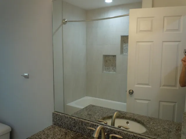 a bathroom with a granite countertop sink and shower