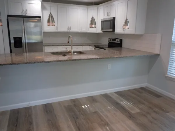 a kitchen with kitchen island a sink appliances and cabinets