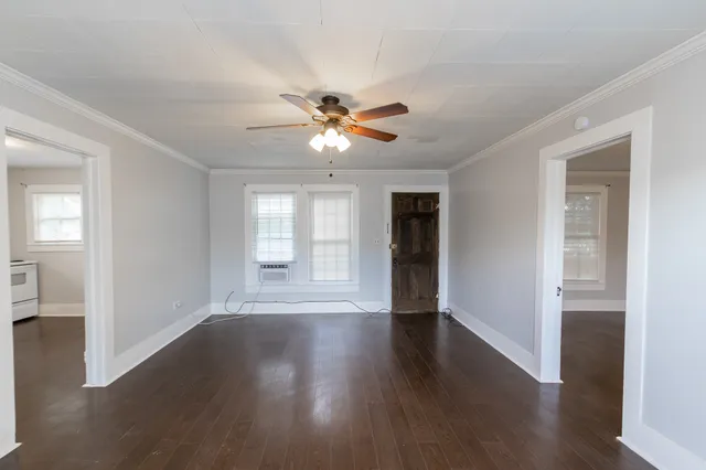 a view of an empty room with a window and wooden floor