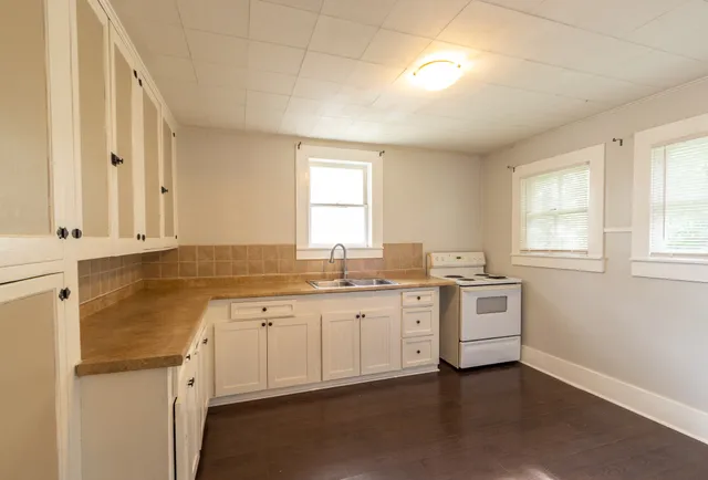 a spacious bathroom with a granite countertop sink mirror and a window