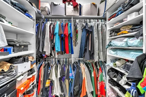 a view of walk in closet with clothes