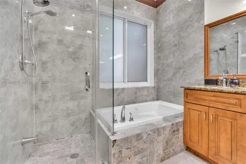a bathroom with a tub sink and mirror