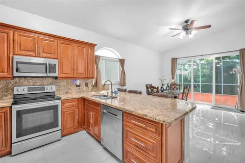 a kitchen with stainless steel appliances granite countertop a stove a sink and a microwave