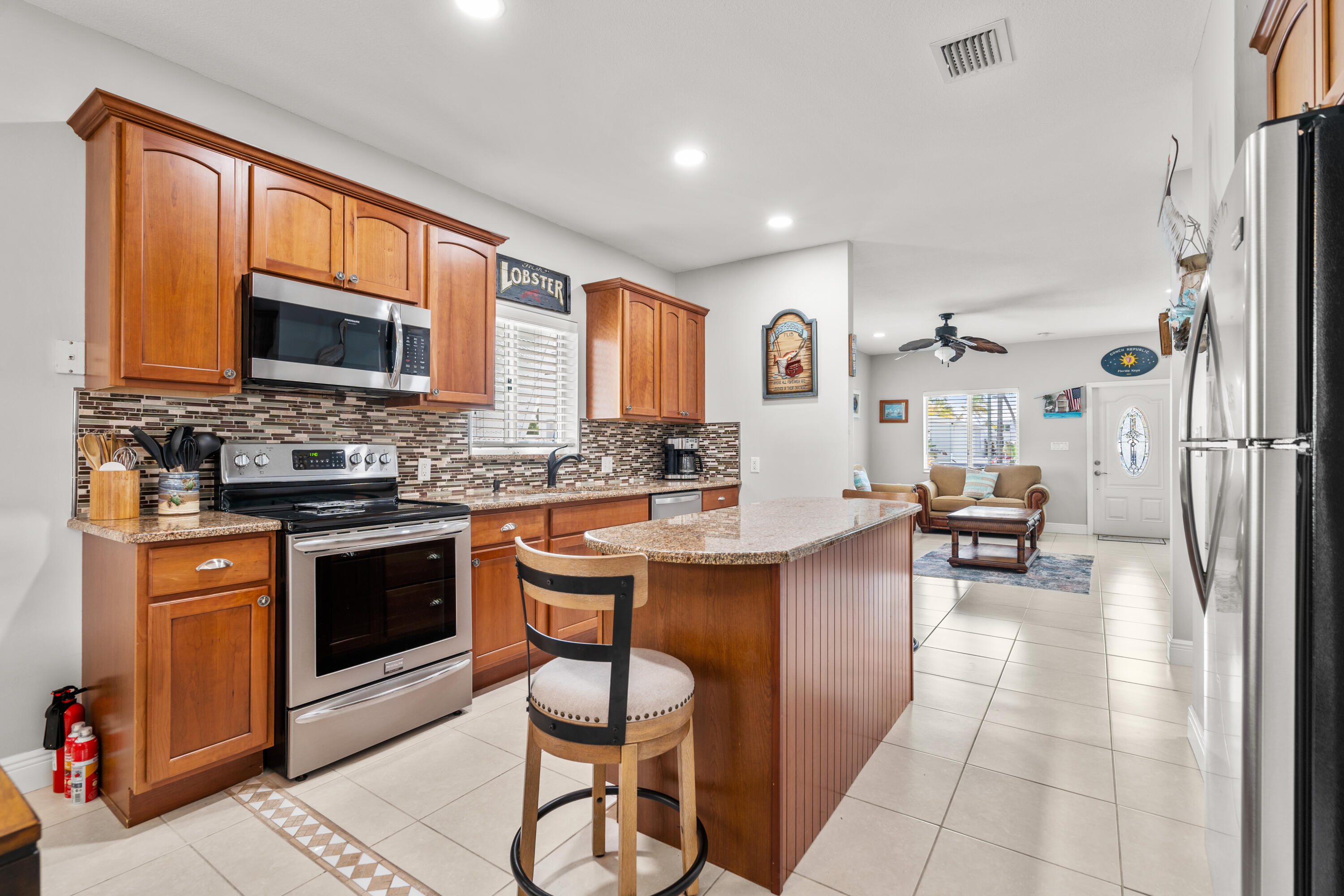 312 Ryan Avenue Key Largo, FL 33037 - Photo 11 of 47 a kitchen with stainless steel appliances granite countertop a stove top oven a sink dishwasher and cabinets with wooden floor