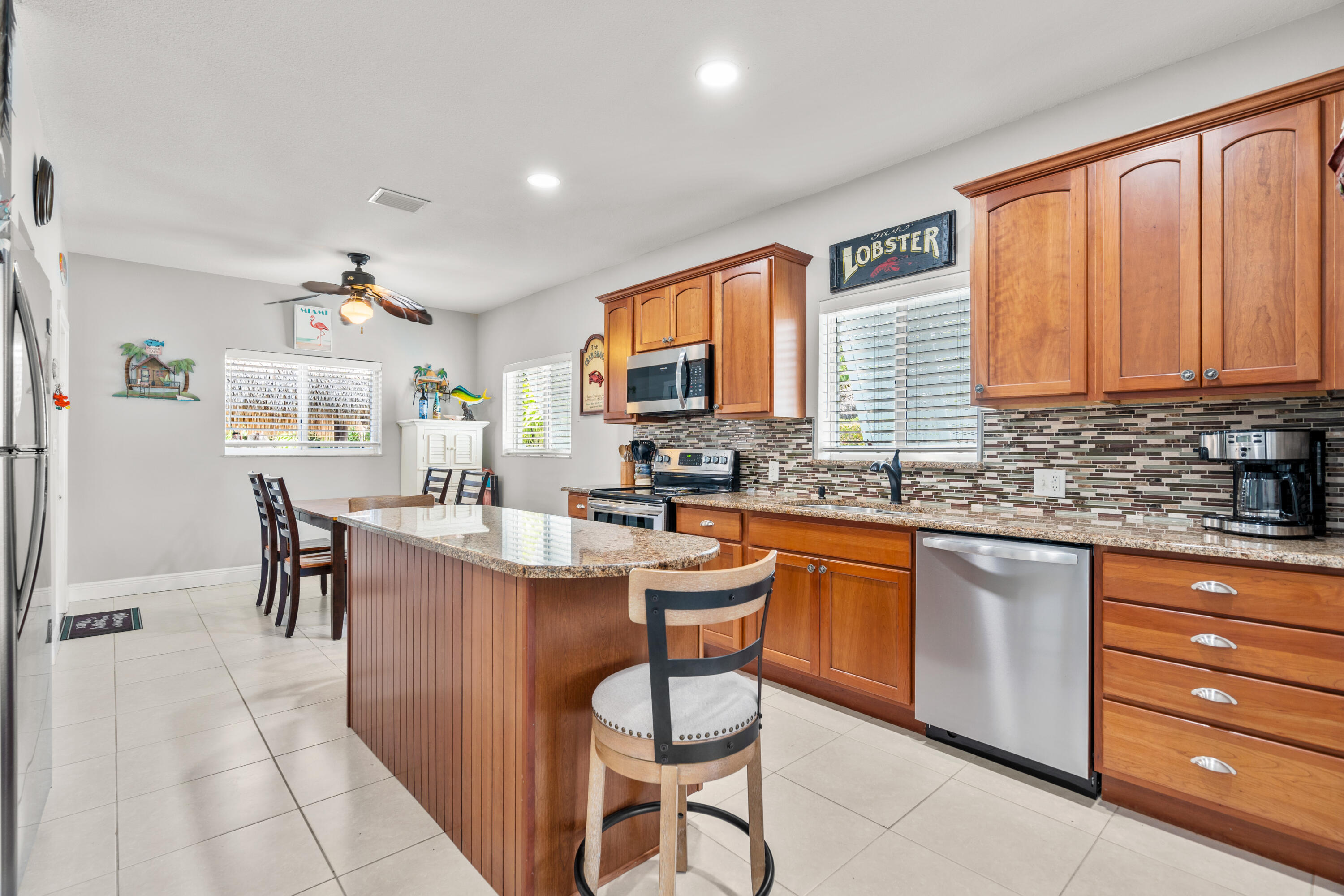 312 Ryan Avenue Key Largo, FL 33037 - Photo 9 of 47 a kitchen with stainless steel appliances granite countertop wooden cabinets a dining table and chairs