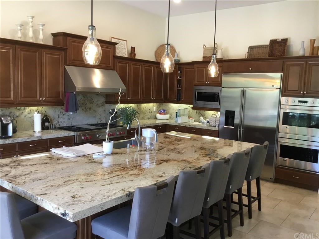 81094 Monarchos Circle La Quinta, CA 92253 - Photo 18 of 43 a kitchen with stainless steel appliances granite countertop a sink refrigerator and microwave
