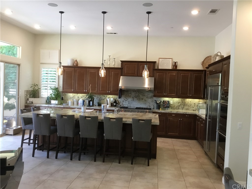 81094 Monarchos Circle La Quinta, CA 92253 - Photo 19 of 43 a kitchen with kitchen island granite countertop a stove a sink a oven a dining table and chairs