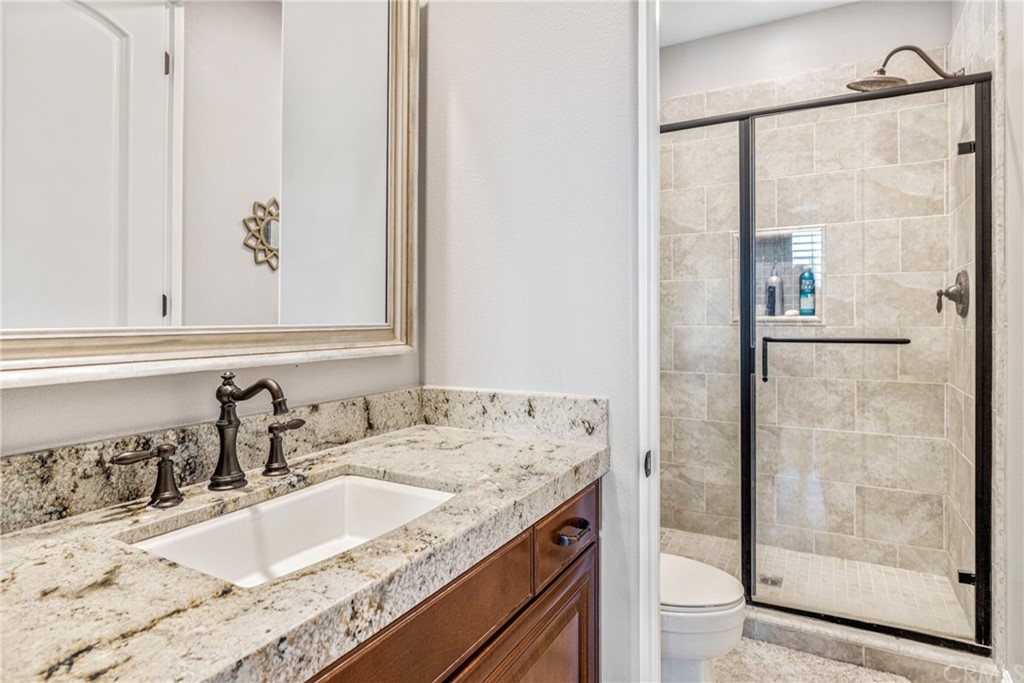 81094 Monarchos Circle La Quinta, CA 92253 - Photo 22 of 43 a bathroom with a granite countertop sink a mirror and shower