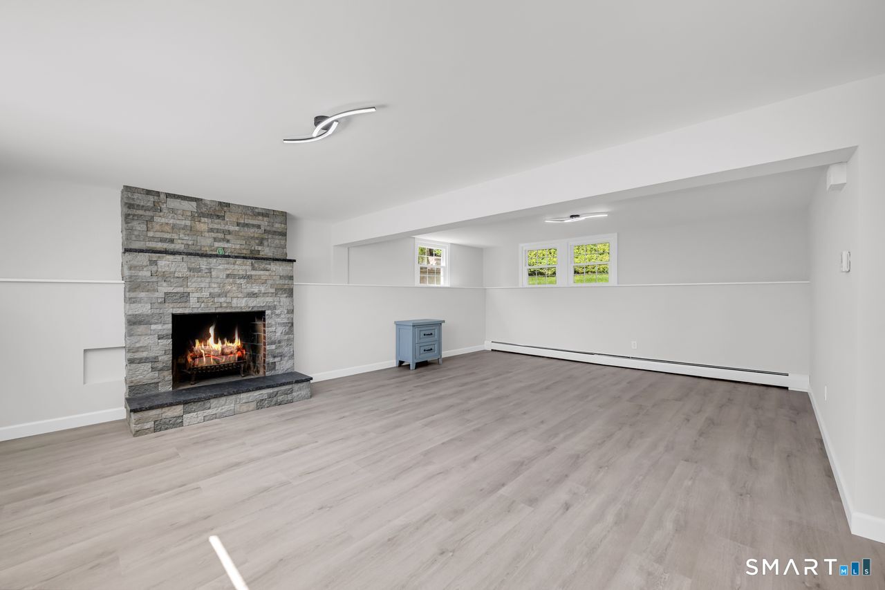 129 Midwell Road Wethersfield, CT 06109 - Photo 20 of 28 Spacious lower-level family room with a second fireplace and a granite leather mantle.