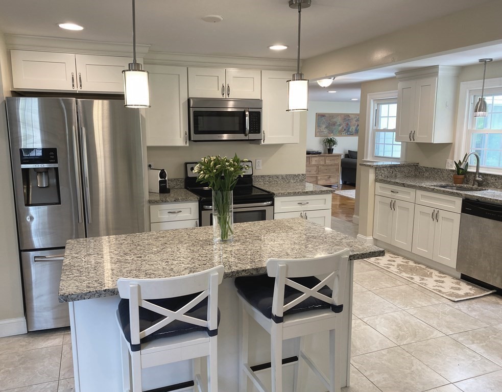13 Pine Knoll Road Lexington, MA 02420 - Photo 2 of 24 a kitchen with stainless steel appliances kitchen island granite countertop a refrigerator a stove a sink a oven with a dining table and chairs