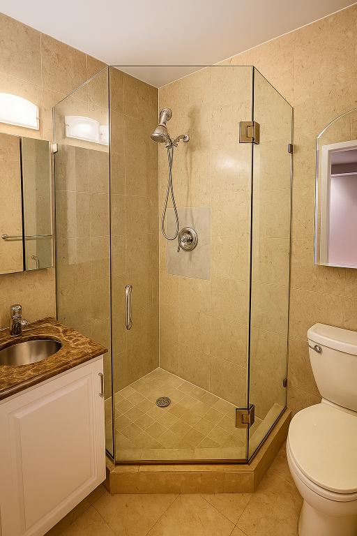 507 East 80th Street, Unit PH8R Manhattan, NY 10075 - Photo 12 of 22 a bathroom with a granite countertop shower a toilet and a sink