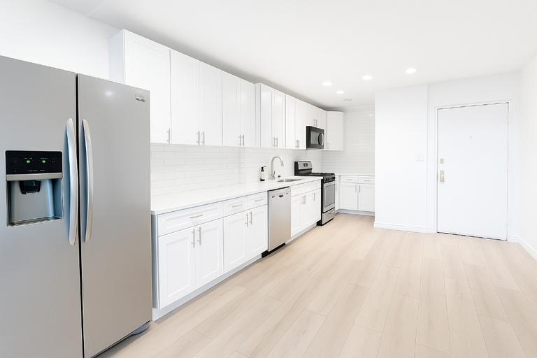 507 East 80th Street, Unit PH8R Manhattan, NY 10075 - Photo 2 of 22 a kitchen with white cabinets and refrigerator