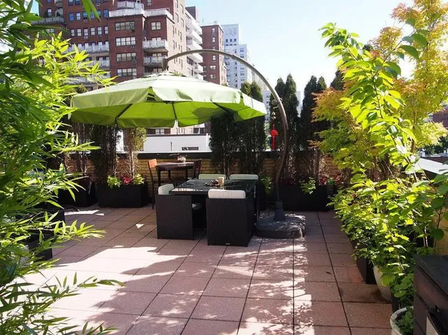a view of a patio with table and chairs under an umbrella