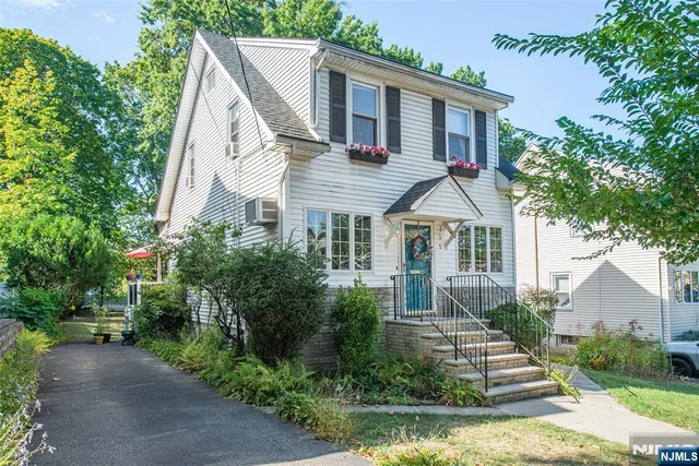 a view of house with a yard and potted plants