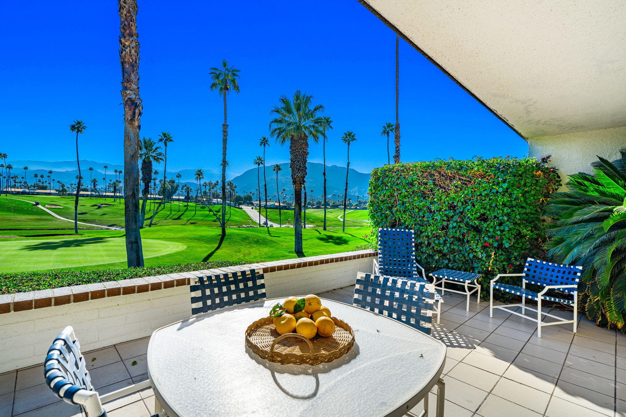 7 Leon Way Rancho Mirage, CA 92270 - Photo 2 of 45 a roof deck with table and chairs potted plants and a palm tree