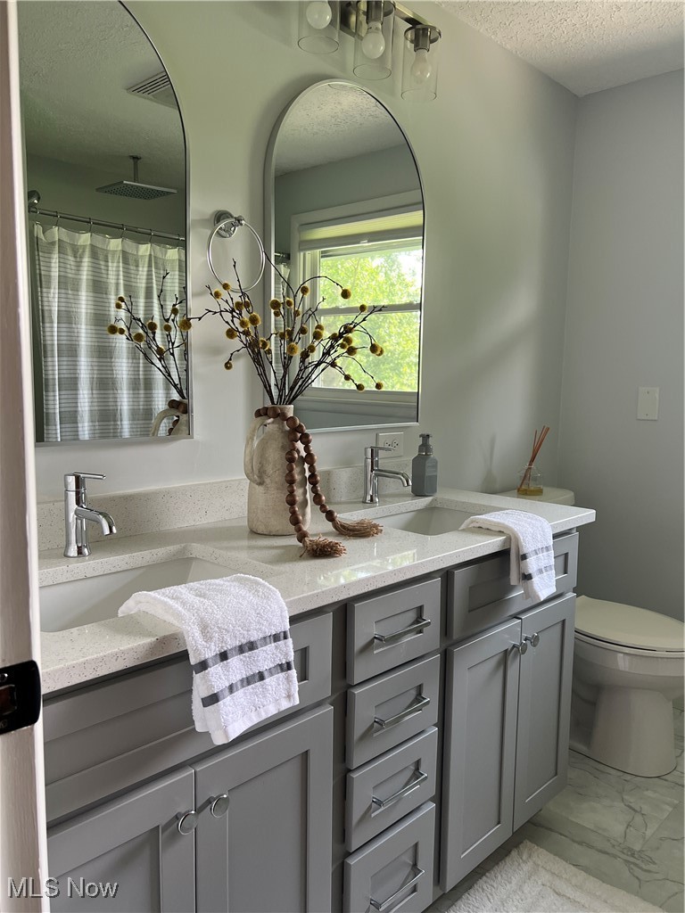 232 Hoffman Road Loudonville, OH 44842 - Photo 26 of 28 Full bathroom featuring double vanity, a textured ceiling, marble finish floors, and a shower with shower curtain