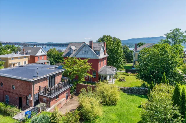 an aerial view of residential house with outdoor space and trees all around