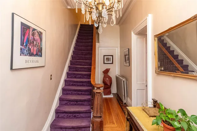 a view of a hallway with wooden floor and stairs