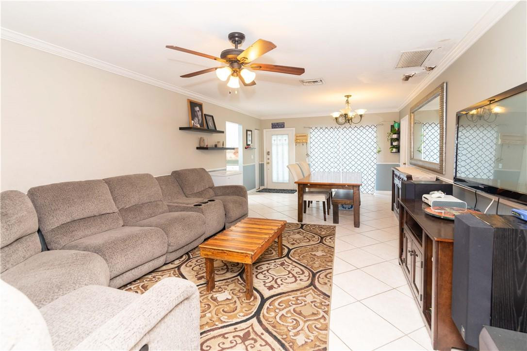 9234 Southwest 5th Street, Unit A Boca Raton, FL 33428 - Photo 2 of 20 a living room with furniture a chandelier and a flat screen tv