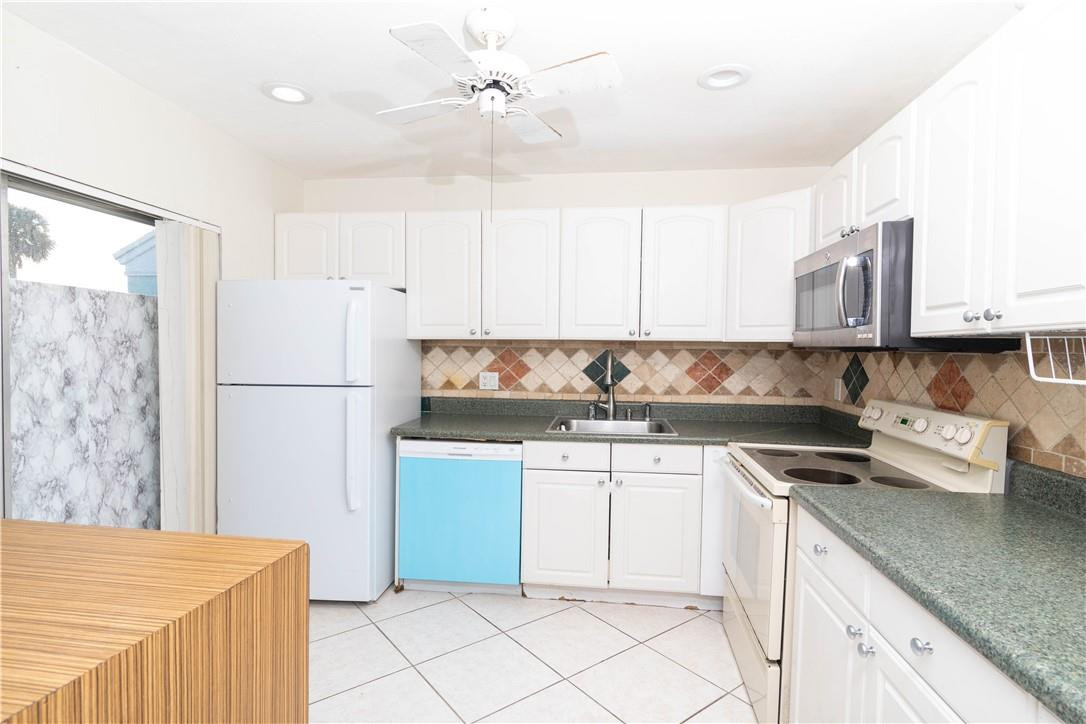 9234 Southwest 5th Street, Unit A Boca Raton, FL 33428 - Photo 6 of 20 a kitchen with stainless steel appliances granite countertop white cabinets stove a sink and dishwasher