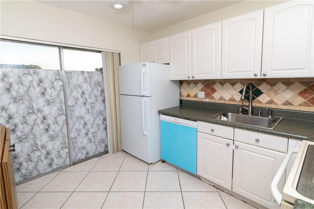 9234 Southwest 5th Street, Unit A Boca Raton, FL 33428 - Photo 8 of 20 a kitchen with a refrigerator and cabinets
