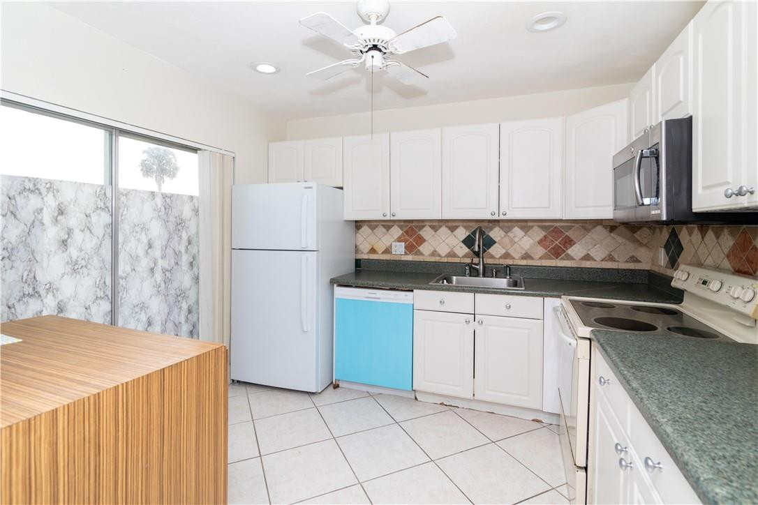 9234 Southwest 5th Street, Unit A Boca Raton, FL 33428 - Photo 9 of 20 a kitchen with a refrigerator sink and cabinets