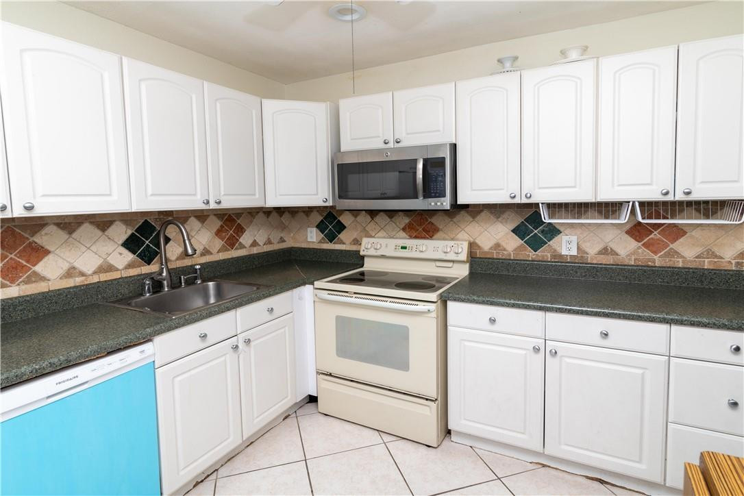 9234 Southwest 5th Street, Unit A Boca Raton, FL 33428 - Photo 10 of 20 a kitchen with white cabinets and white appliances
