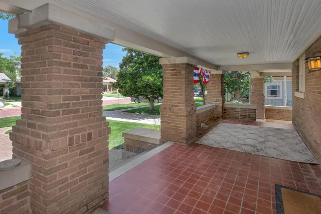 an empty room with windows fireplace and wooden floor