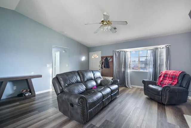 a living room with furniture a flat screen tv and a window