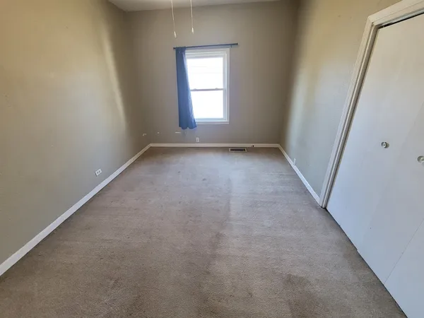 an empty room with mirror and door
