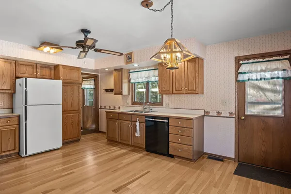 a kitchen with a refrigerator a sink and wooden floor