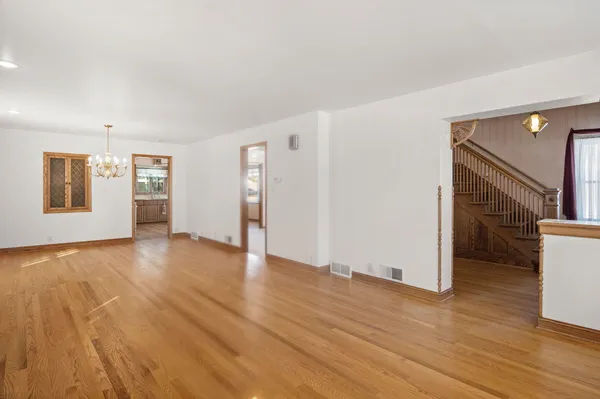 a view of empty room with wooden floor and window