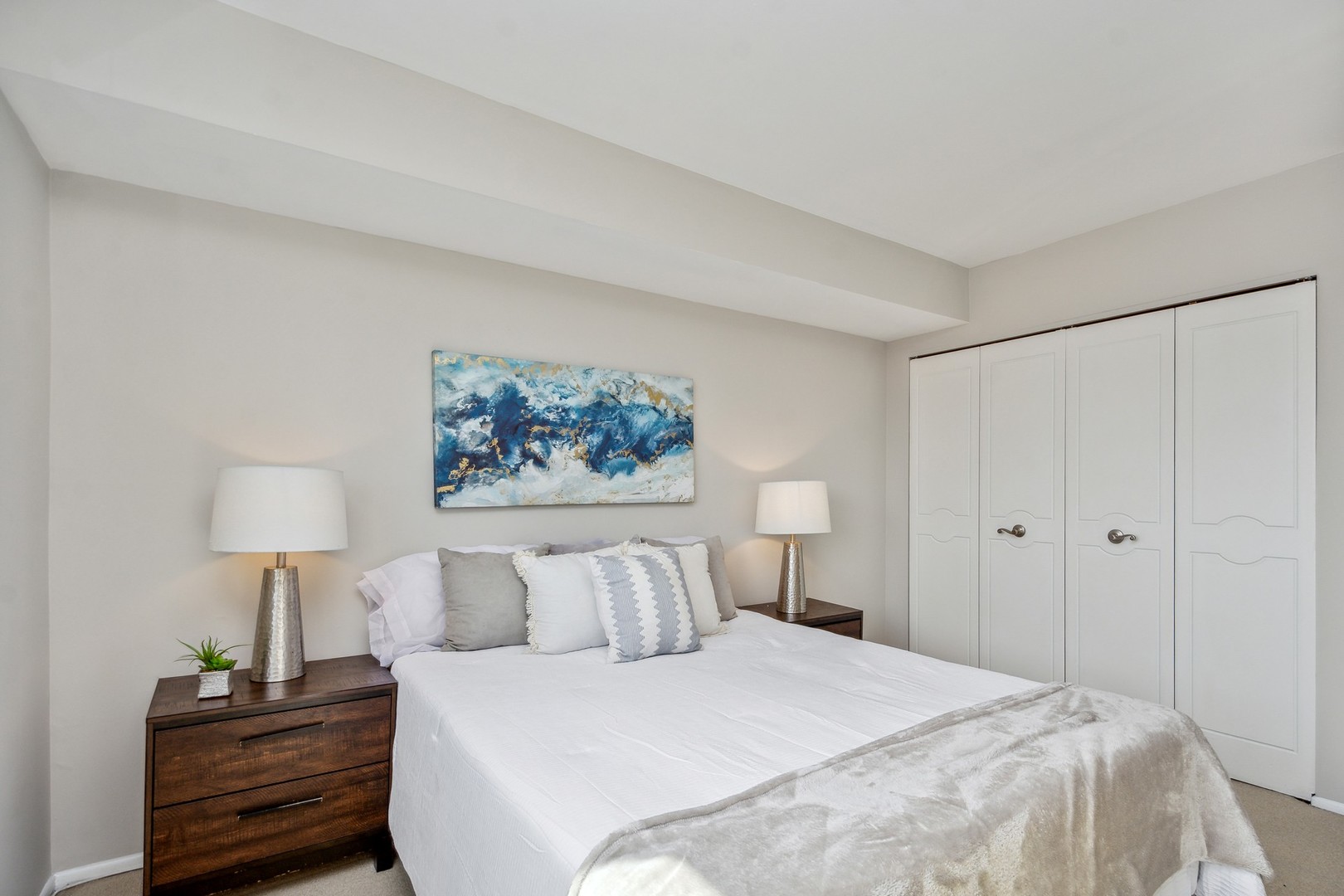 7200 North Ridge Boulevard, Unit 4E Chicago, IL 60645 - Photo 15 of 21 a bedroom with a bed and a lamp on dresser