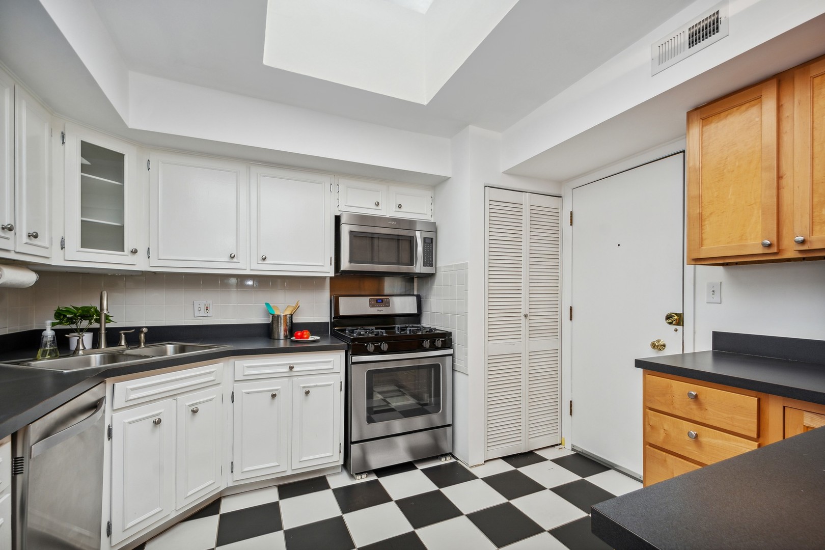 7200 North Ridge Boulevard, Unit 4E Chicago, IL 60645 - Photo 8 of 21 a kitchen with stainless steel appliances granite countertop white cabinets granite counter tops and a stove top oven