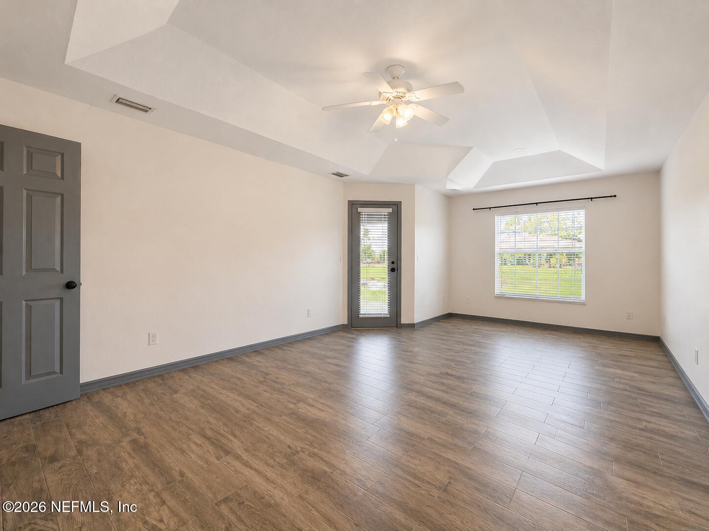 4728 Innisbrook Court North Elkton, FL 32033 - Photo 17 of 28 an empty room with wooden floor and windows