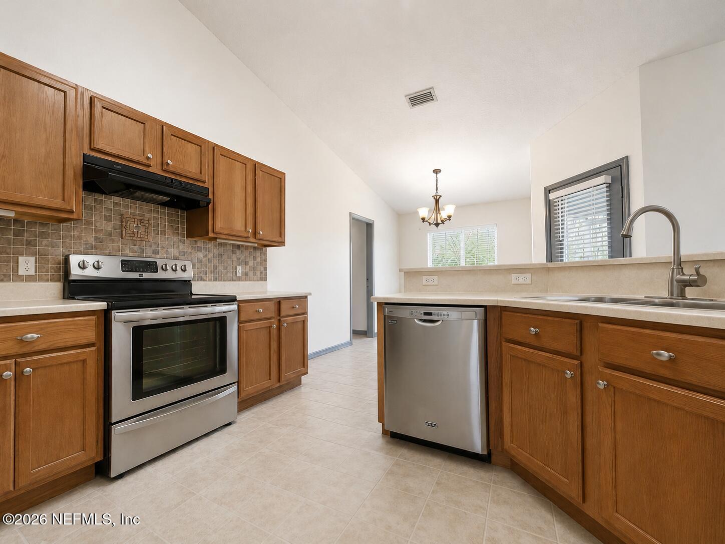 4728 Innisbrook Court North Elkton, FL 32033 - Photo 6 of 28 a kitchen with stainless steel appliances granite countertop a stove a sink dishwasher and a microwave oven with cabinets